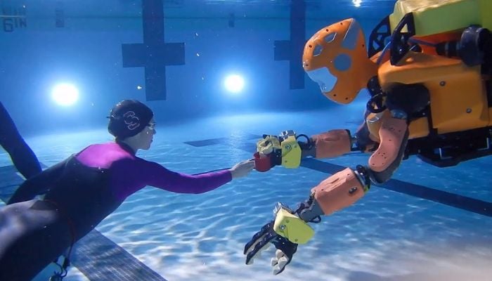 Ekran görüntüsü, derin su robotu OceanOneK'lı bir kadını gösteriyor.