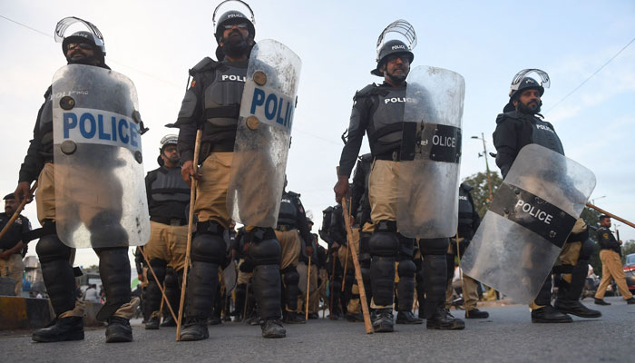 Polis, eski Pakistan başbakanı Imran Khan'ın destekçilerinin 5 Kasım 2022'de Karaçi'de kendisine yönelik suikast girişimine karşı düzenlediği protesto sırasında nöbet tutuyor. — AFP/File