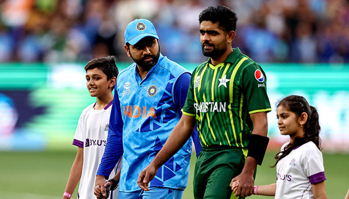 Hindistan'dan Rohit Sharma (solda) ve Pakistan'dan Babar Azam, 23 Ekim 2022'de Melbourne'deki Melbourne Cricket Ground'da (MCG) Hindistan ile Pakistan arasında ICC erkekler Twenty20 Dünya Kupası 2022 kriket maçında takımlarını sahaya çıkarıyor. - AFP