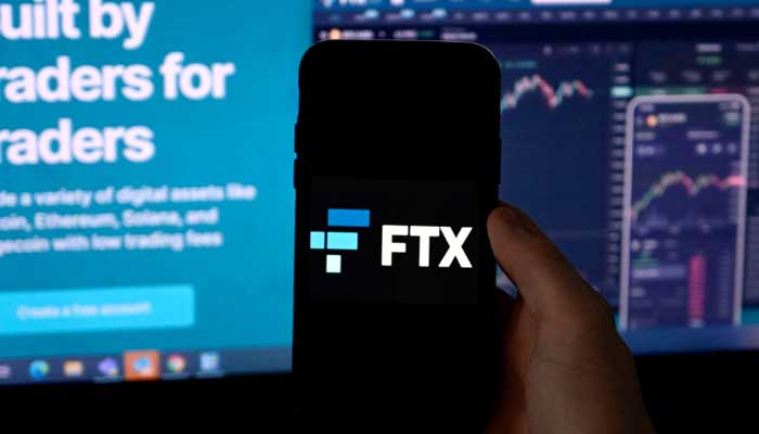 In this file photo illustration taken on February 09, 2022, shows a smart phone screen displaying the logo of FTX, the crypto exchange platform, with a screen showing the FTX website in Arlington, Virginia. — AFP