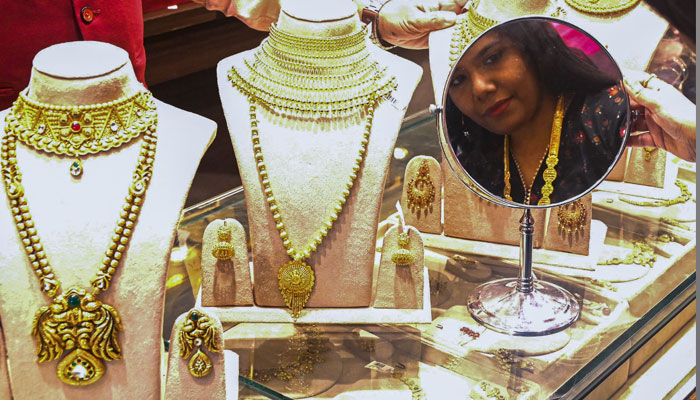 A female customer tries on a gold necklace at a Senco Gold and Diamonds jewellery showroom in Mumbai on October 22, 2022. — AFP/File