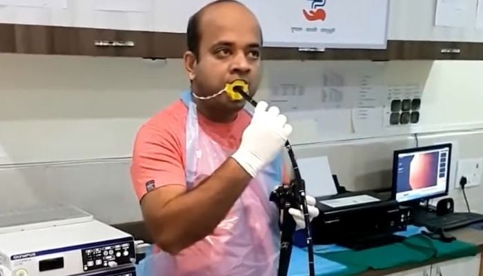 Screengrab mostra il dottor Nitin Joshi mentre esegue l'endoscopia su se stesso.— Twitter