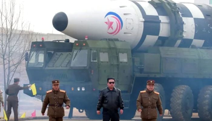 Kuzey Kore lideri Kim Jong Un (C), devlet medyasının yeni tip bir kıtalararası balistik füze olduğunu söylediği raporun yakınında yürüyor.— AFP/dosya
