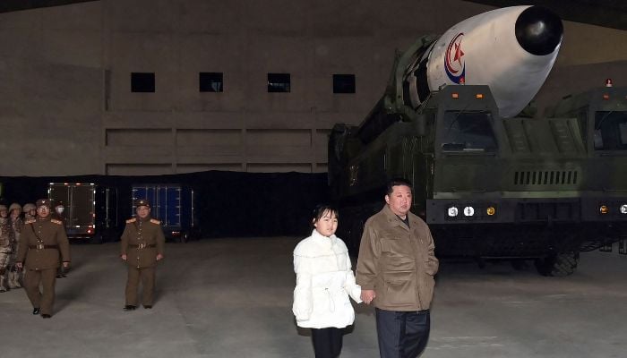 18 Kasım 2022'de çekilen ve 19 Kasım 2022'de Kuzey Kore'nin resmi Kore Merkez Haber Ajansı'ndan (KCNA) yayınlanan bu fotoğraf, Kuzey Kore lideri Kim Jong Un'u (sağda) kızıyla birlikte yeni bir kıtalararası teftiş ederken gösteriyor. balistik füze (ICBM) Hwasong Gun 17, Pyongyang Uluslararası Havalimanı'ndaki lansmanından önce.  Devlet medyası 19 Kasım'da, Kim'in Pyongyang'ın en son kıtalararası balistik füze fırlatmasını şahsen denetlemesinin ardından, Kuzey Kore lideri Kim Jong Un'un ABD tehditlerine nükleer silahlarla yanıt vereceğini söyledi.— AFP