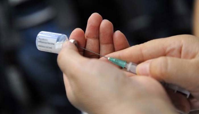 Un operatore sanitario riempie un'iniezione monouso con un medicinale.— AFP/File