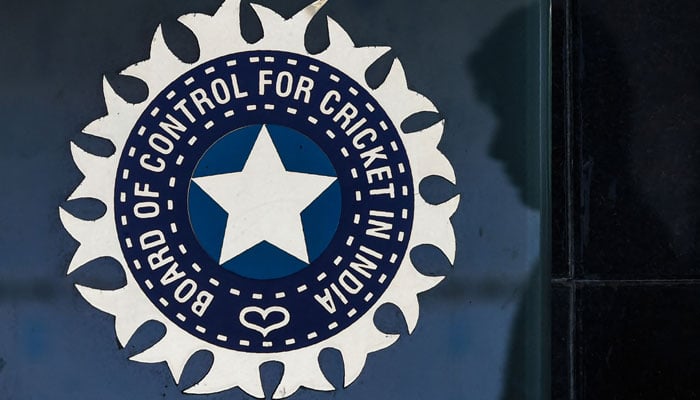 This file photo taken on May 22, 2016 shows a member of staff walking past the logo of the Board of Control for Cricket in India (BCCI) outside its headquarters in Mumbai. — AFP/File