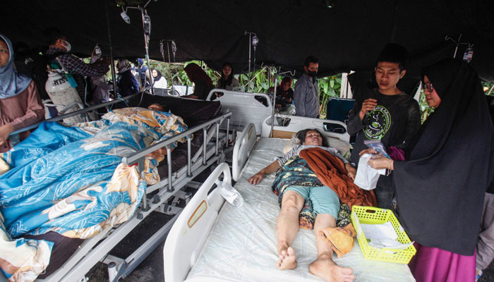 21 Kasım 2022'de Cianjur'da meydana gelen depremin ardından yaralılar bir hastanenin önünde sergilenen çadırın altında yatıyor. — AFP