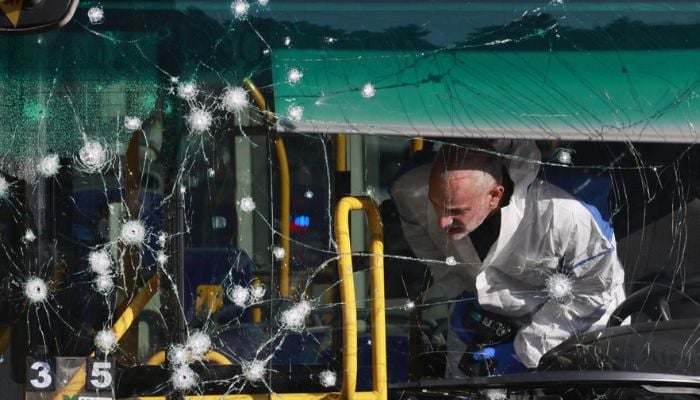 An Israeli forensic scientist inspects the inside of a bus damaged in one of the twin blasts that hit Jerusalem early Wednesday.— AFP