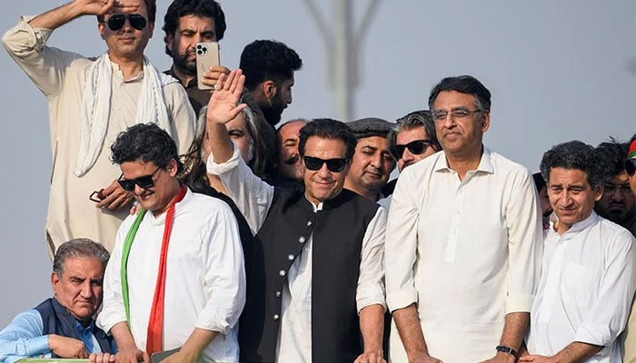 PTI chief Imran Khan waves hands to supporters along with other senior party leaders during its long march. — AFP/File