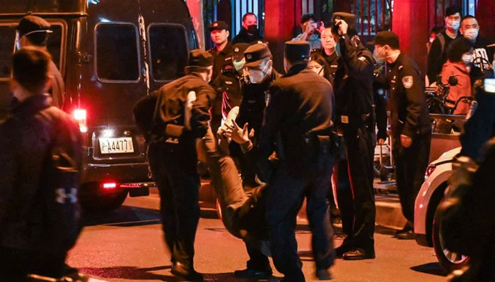 A man is arrested while people gathering on a street in Shanghai on November 27, 2022, where protests against Chinas zero-Covid policy took place the night before following a deadly fire in Urumqi, the capital of the Xinjiang region. — AFP
