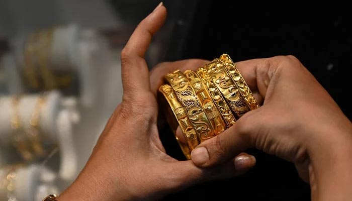 An undated image of a woman looking at gold bangles at a jewellery store. — AFP/File