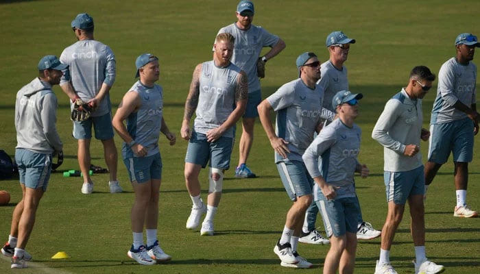 İngiltere kaptanı Ben Stokes (şu), 28 Kasım 2022'de Rawalpindi'deki Rawalpindi Kriket Stadyumu'nda Pakistan'a karşı oynayacakları ilk kriket Testi maçından önce takım arkadaşlarıyla birlikte ısınıyor. — AFP