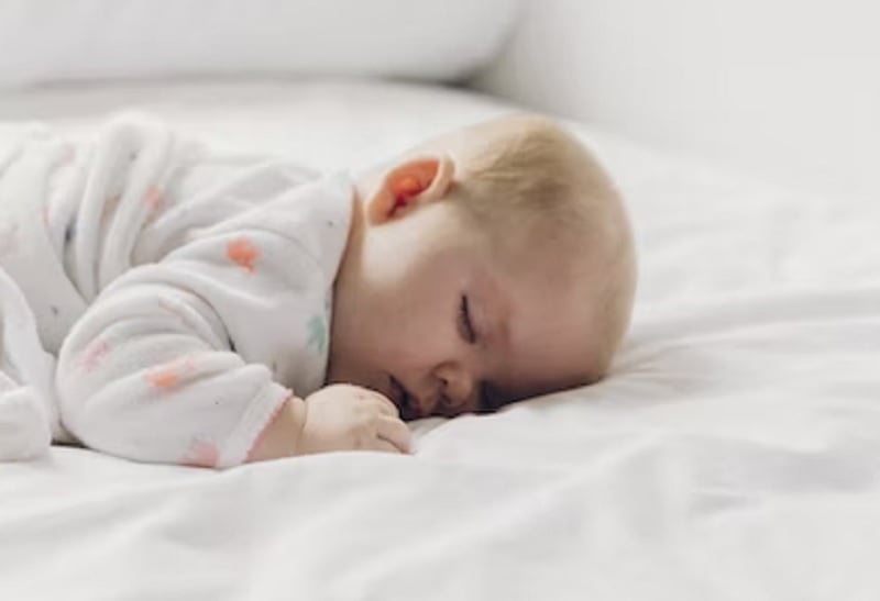 A baby sleeping on the bed.— Unsplash