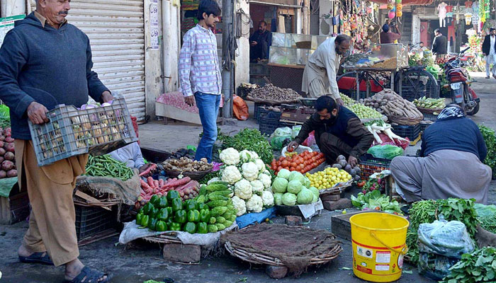 A vendor selling vegetables at Gol bazar in Sargodha. — APP/File