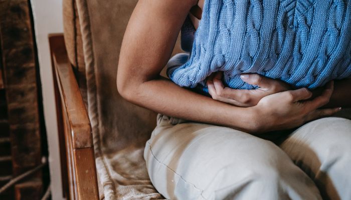 Woman suffering from a stomach pain.— Pexels