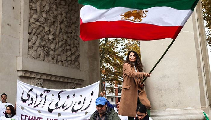 A protestor waves the Iranian flag during a rally in support of the demonstrations in Iran, in Toulouse, south-western France, on December 3, 2022. — AFP