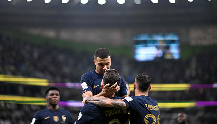 Frances forward #09 Olivier Giroud celebrates with Frances forward #10 Kylian Mbappe (top) after scoring his teams first goal during the Qatar 2022 World Cup round of 16 football match between France and Poland at the Al-Thumama Stadium in Doha on December 4, 2022. — AFP