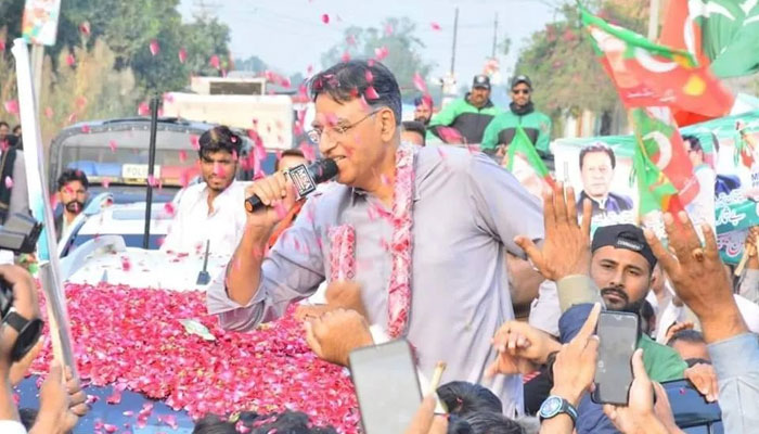 PTI Secretary General Asad Umar receives welcome as his convoy arrives in Makkuana, Faisalabad, during partys long march. — Instagram/@asadumarofficial