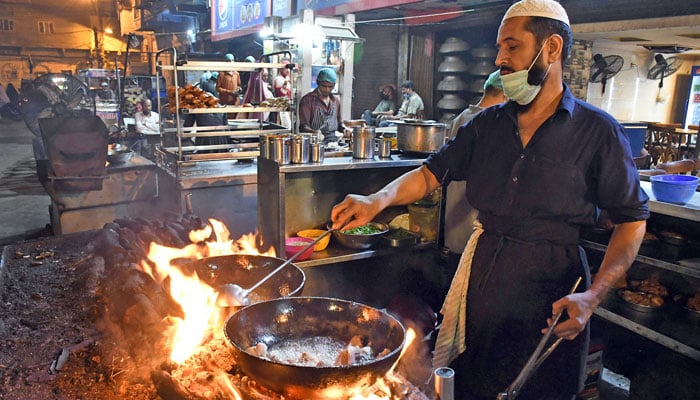 A worker is preparing traditional food “Chicken Karahi” at Burns road street food in Karachi. — Online/File