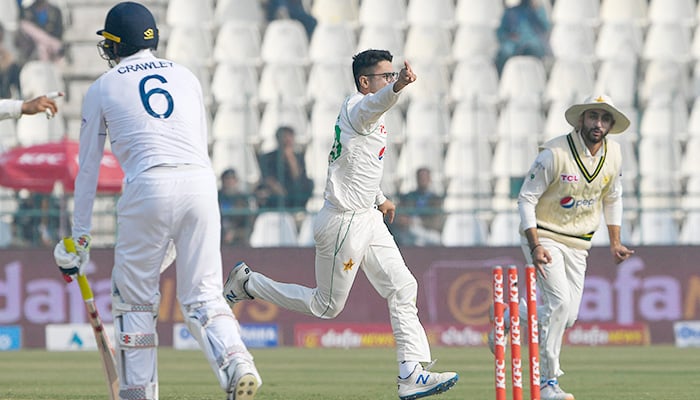 Pakistans Abrar Ahmed (C) celebrates after taking the wicket of Englands Zak Crawley (L) during the first day of the second cricket Test match between Pakistan and England at the Multan Cricket Stadium in Multan on December 9, 2022. — AFP