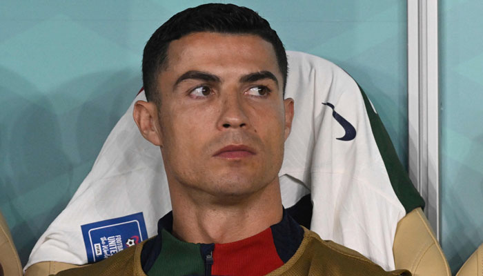 Portekiz'in forveti #07 Cristiano Ronaldo, 10 Aralık 2022'de Doha'daki Al-Thumama Stadyumu'nda Fas ile Portekiz arasında oynanan Katar 2022 Dünya Kupası çeyrek final futbol karşılaşmasının başında yedek kulübesinde oturuyor. — AFP