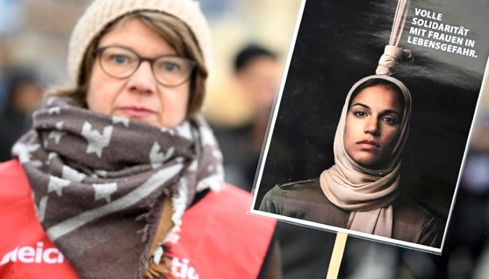 İran'ın İslam Cumhuriyeti'ndeki protestolarla bağlantılı ilk infazını gerçekleştirmesinin ardından Berlin'deki bir gösterici, ölüm tehlikesi altındaki kadınlarla dayanışma posteri taşıyor.  — AFP/Dosya