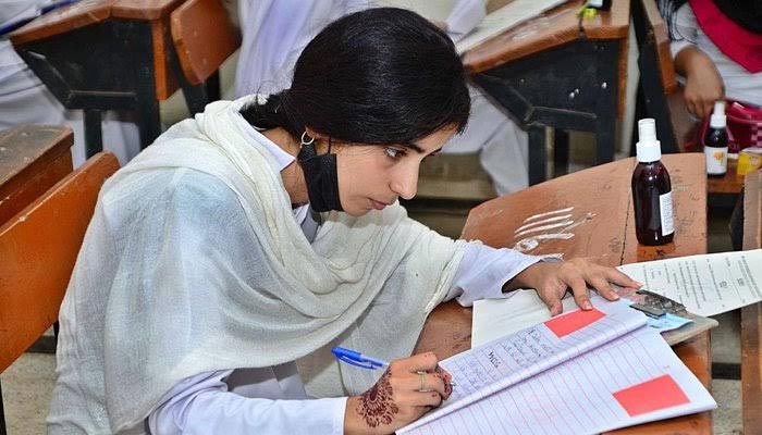 A student can be seen attempting her exam paper in this undated image. — APP/File