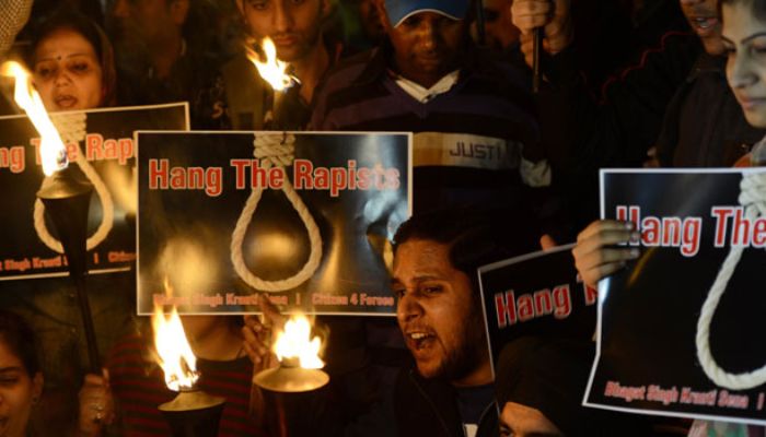 Hintli öğrenciler ve aktivistler, Yeni Delhi'de bir öğrencinin toplu tecavüze uğramasının ardından düzenlenen bir protesto sırasında Hindistan Kapısı'nda meşaleler taşırken sloganlar atıyorlar, 19 Aralık 2012.— AFP