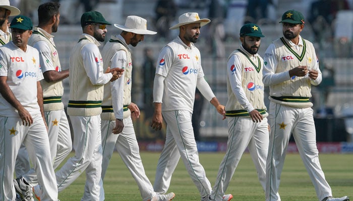 Pakistans captain Babar Azam (R) and teammates walk back to the pavilion after England was all out during the third day of the second cricket Test match between Pakistan and England at the Multan Cricket Stadium in Multan on December 11, 2022. — AFP