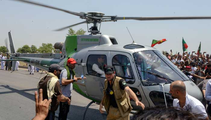 Ousted PM Imran Khan arrives on a helicopter to lead a protest rally in Swabai on May 25, 2022. —AFP