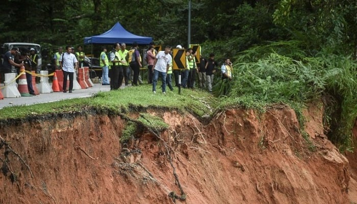 Rescue workers scoured muddy terrain for survivors and bodies as the death toll from a landslide at a Malaysian campsite rose to 21. - AFP