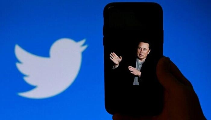 A phone screen displays a photo of Elon Musk with the Twitter logo shown in the background, in Washington, DC, October 4, 2022. — AFP/File