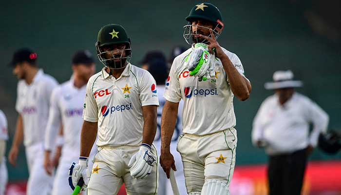 Pakistans Abdullah Shafique (L) and Shan Masood (R) walk back to the pavilion at the end of play of second day of the third cricket Test match between Pakistan and England at the National Stadium in Karachi on December 18, 2022.