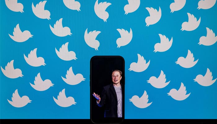 This file photo illustration taken on August 05, 2022, shows a cellphone displaying a photo of Elon Musk placed on a computer monitor filled with Twitter logos in Washington, DC. — AFP