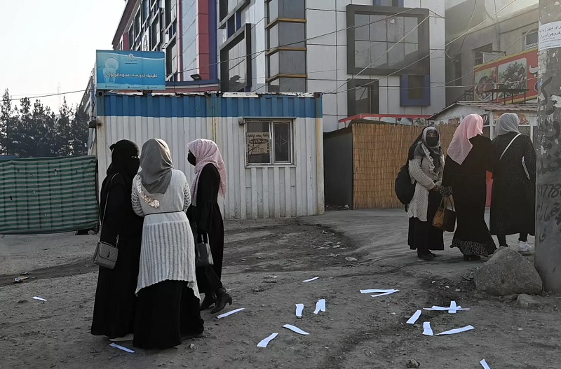 Groups of students gathered outside university entrances to discuss the Talibans ban on their further education.— AFP