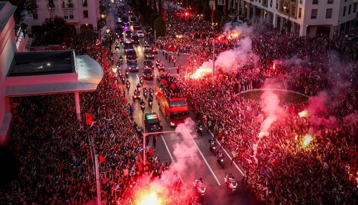 Supporters light flares and cheer as Morocco´s national football team arrives to the center of the capital Rabat, on December 20, 2022, after the Qatar 2022 World Cup.— AFP