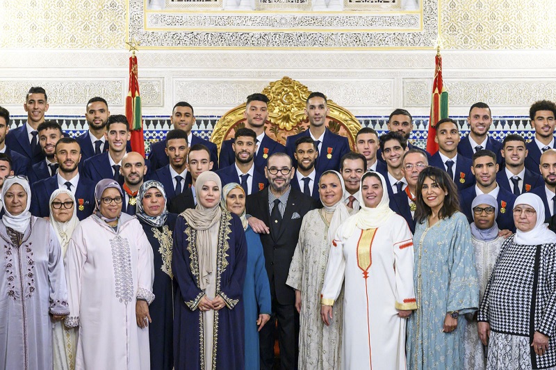 This handout picture released by the Moroccan National Press Agency on December 20, 2022, shows Morocco´s King Mohammed VI (C) posing for a picture with the country´s national football team players and their relatives at the royal palace of Rabat, upon their return after the Qatar 2022 World Cup.— AFP