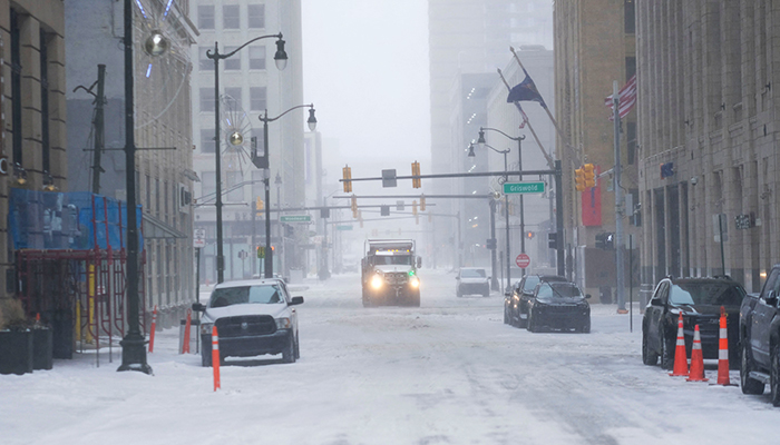 Snow removal vehicles try to clear roads in downtown Detroit on December 23, 2022 in Detroit, United States. — AFP