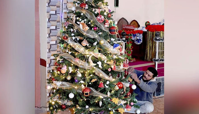 Hristiyanlar, 24 Aralık 2022'de Larkana'da Noel arifesinde St Joseph Katolik Kilisesi'ni süslüyor. — APP