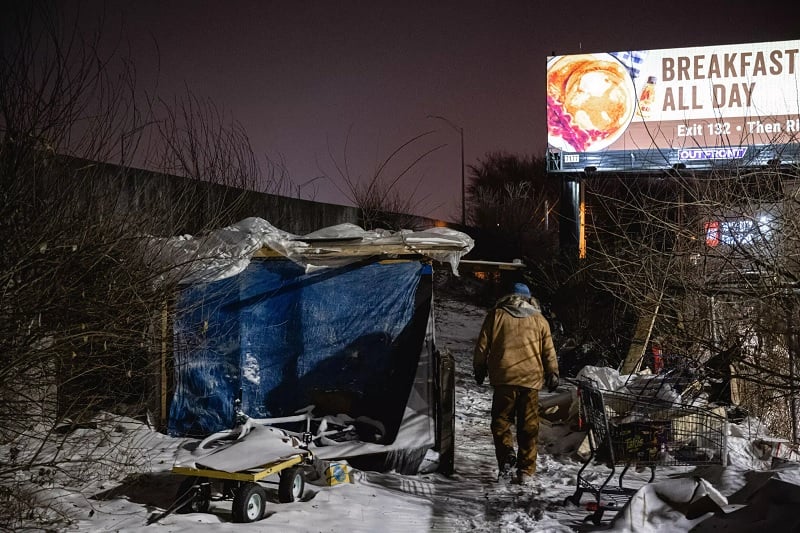 An outreach worker delivers supplies to people living in a homeless camp on December 23, 2022 in Louisville, Kentucky, as a major storm hammers US communities with temperatures 40 degrees below average ahead of the Christmas holiday.— AFP