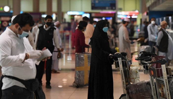 Pakistan vatandaşları, yeni koronavirüs pandemisi krizinin ortasında, 7 Mayıs 2020 tarihli bu dosya fotoğrafında ülkelerine dönmek üzere Körfez Emirliği'nden ayrılmadan önce Dubai Uluslararası Havalimanı'nda check-in yapıyor.  — AFP/ dosya