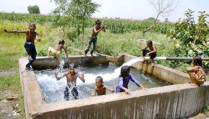Children bathe in a tube-well to get some relief from scorching hot weather. — APP/File