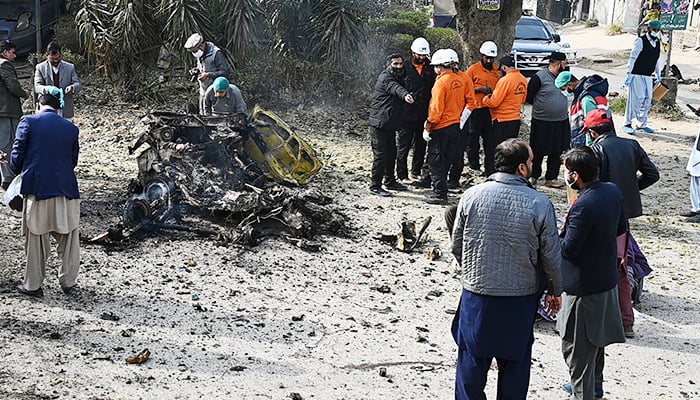 Policemen collect evidence at the suicide blast site in Islamabad on December 23, 2022. — AFP