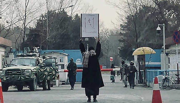 This picture taken on December 25, 2022 shows student Marwa protesting alone against the ban on wome´s higher education, outside the Kabul University as members of Taliban stand guard in Kabul. — AFP