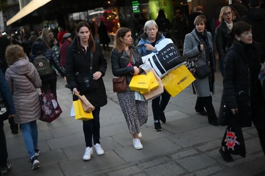 Alışveriş yapanlar, 25 Kasım 2022'de Londra'nın merkezinde Kara Cuma günü satın aldıkları ürünleri Selfridges markalı alışveriş poşetlerinde taşıyor.— AFP/dosya