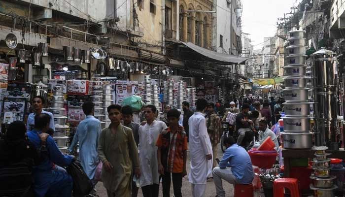 People shop in a Karachi market. — AFP/File