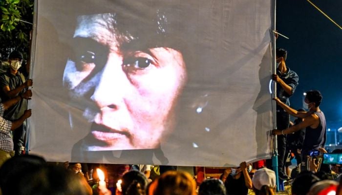 13 Mart 2021'de çekilen bu dosya fotoğrafında, protestocuların Yangon'daki askeri darbeye karşı gece düzenlediği gösteri sırasında gözaltına alınan sivil lider Aung San Suu Kyi'nin bir görüntüsü ekrana yansıtılıyor.— AFP