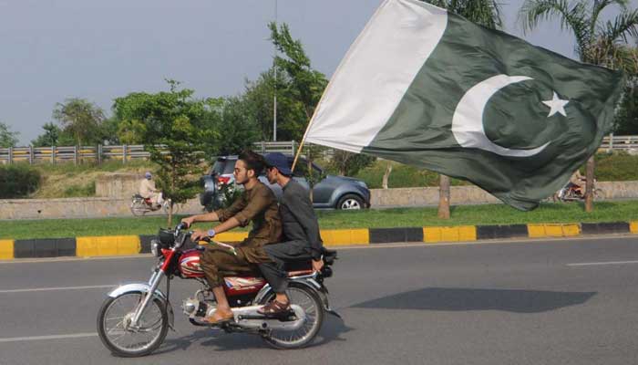 Youngsters on the motorbike holding National Flag to celebrate the occasion of 75th Independence Day at Federal Capital on August 14, 2022. — APP