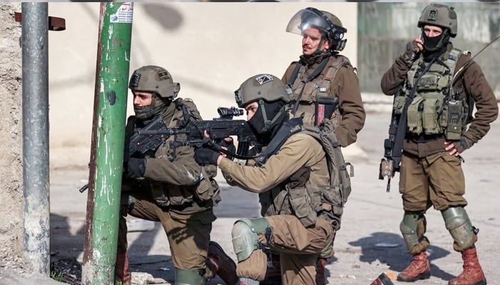 Israeli soldiers take aim during clashes with Palestinian protesters in the centre of the city of Hebron in the occupied West Bank on March 4, 2022. — AFP
