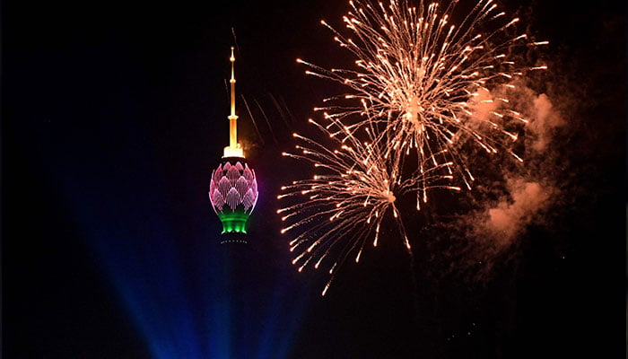1 Ocak 2023'te çekilen bu fotoğraf, Kolombo'daki Yeni Yıl kutlamaları sırasında yanan Lotus Kulesi'nin yanında gökyüzündeki havai fişekleri gösteriyor.  — AFP